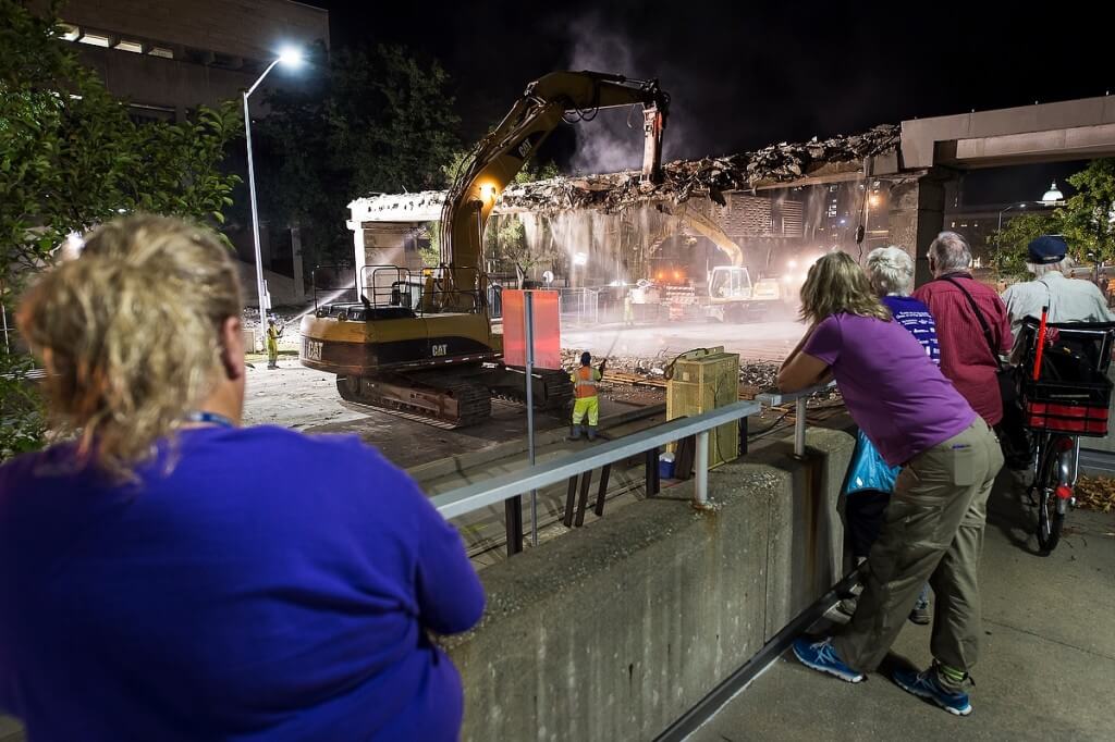 A 1970s-era bridge comes tumbling down in August as spectators watch construction workers demolish the deteriorating structure between the Mosse Humanities Building, left, and Vilas Hall, foreground.