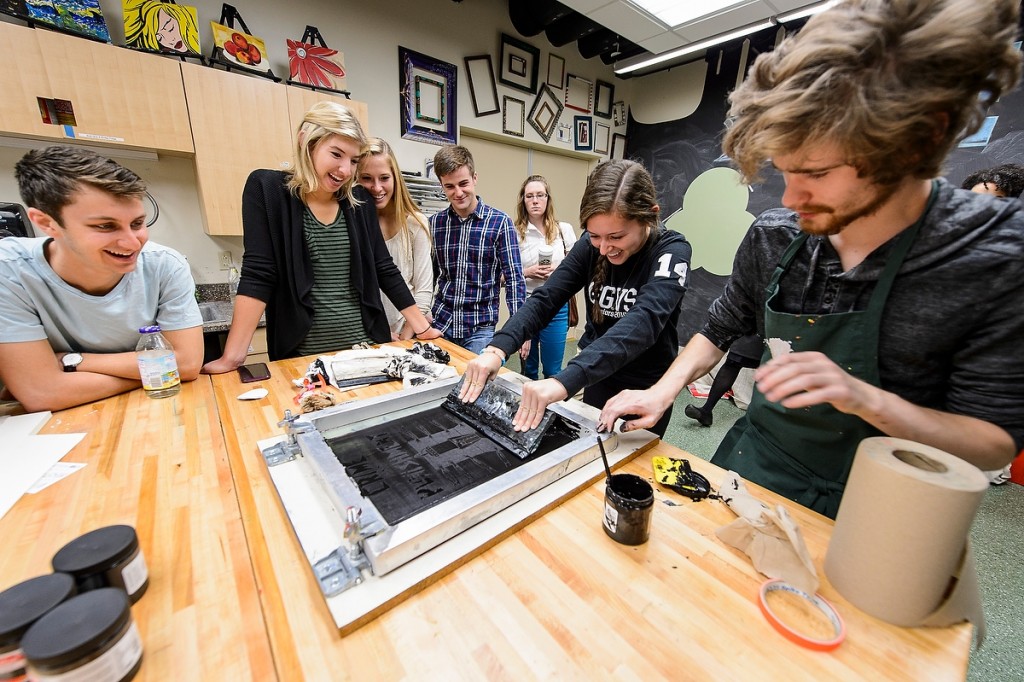 Tangible results are revealed as students in a business school class use silk-screening techniques at Wheelhouse Studios to create posters related to “Just Mercy,” this year’s selection for Go Big Read.