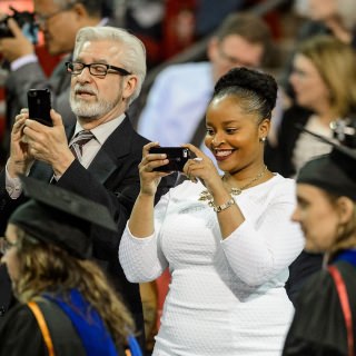 Proud family members capture the moment during commencement exercises for graduate and professional students Friday, May 13, at the Kohl Center.