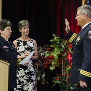 Riseling leads Assistant Chief Brian Bridges in the oath of office as Bridges accepts the role of interim chief.