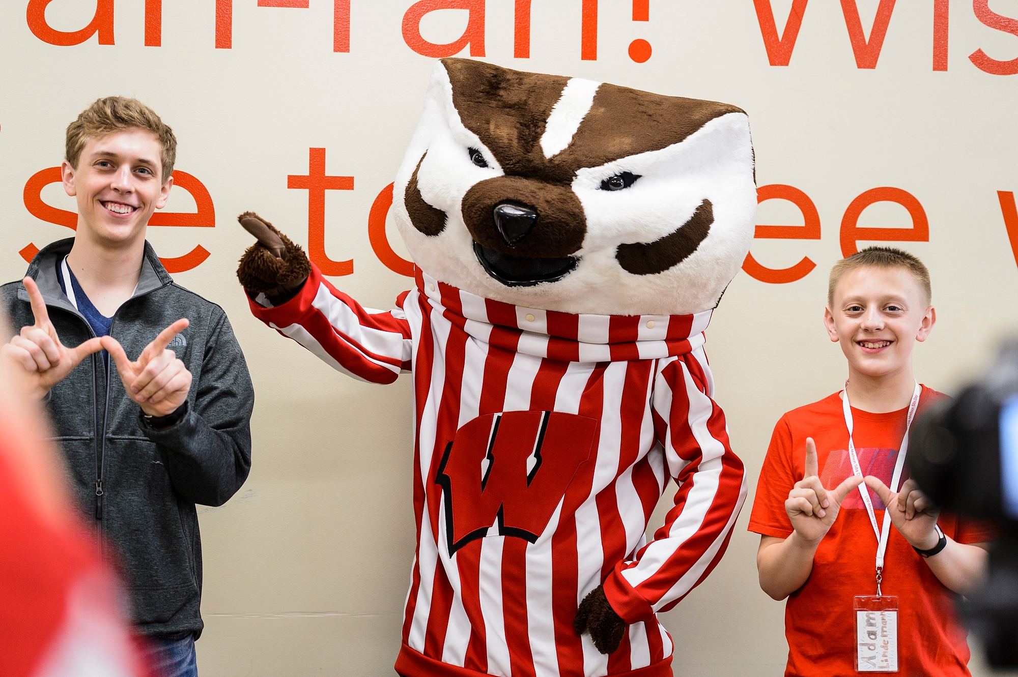 Undergraduate Jacob Lindemann and his brother Adam, 13, of Manitowoc, pose for a photo with mascot Bucky Badger at Union South during Sibs Day activities.