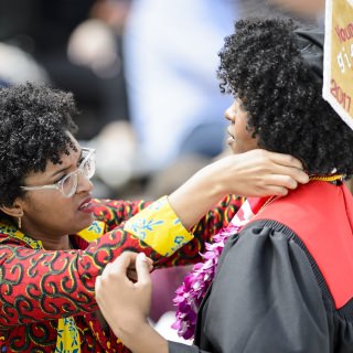 A graduate gets help with her gown.