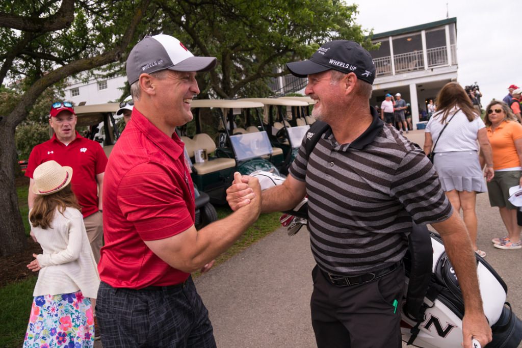 Pro golfer Jerry Kelly, right, gives a hearty handshake to Mark Osiecke, assistent men's hockey coach.