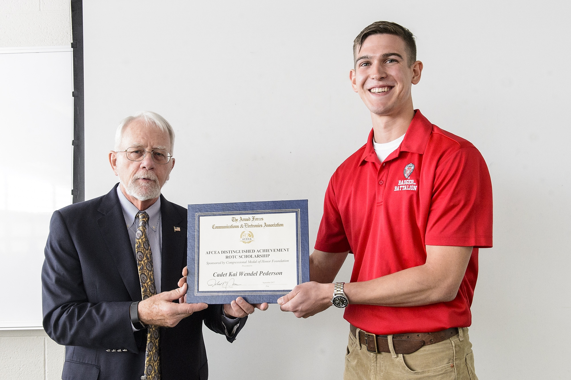 Army ROTC cadet Kai Pederson (right), a UW-Madison junior, receives the Distinguished Achievement Scholarship from Ronald T. Rand (left), a retired U.S. Air Force brigadier general and president and CEO of the Congressional Medal of Honor Foundation, during a ceremony.