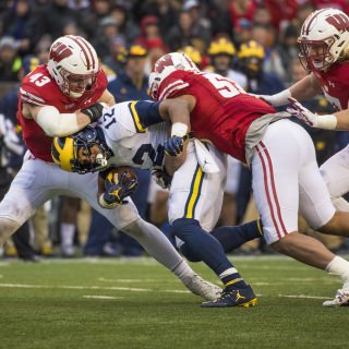 Photo of linebacker Ryan Connelly, left, and T.J. Edwards bringing down Michigan running back Chris Evans.