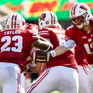 Wisconsin quarterback Alex Hornibrook (12) hands off the ball to running back Jonathon Taylor (23) as the Wisconsin Badgers take on the Maryland Terrapins during a UW Homecoming football game at Camp Randall Stadium at the University of Wisconsin-Madison on Oct. 21, 2017. Wisconsin won the game, 38-13. (Photo by Jeff Miller / UW-Madison)