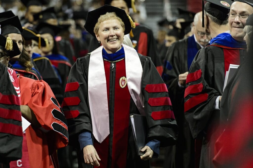 Photo of Dean of Students Lori Berquam walking towards the stage during UW-Madison's spring commencement ceremony Friday at the Kohl Center.