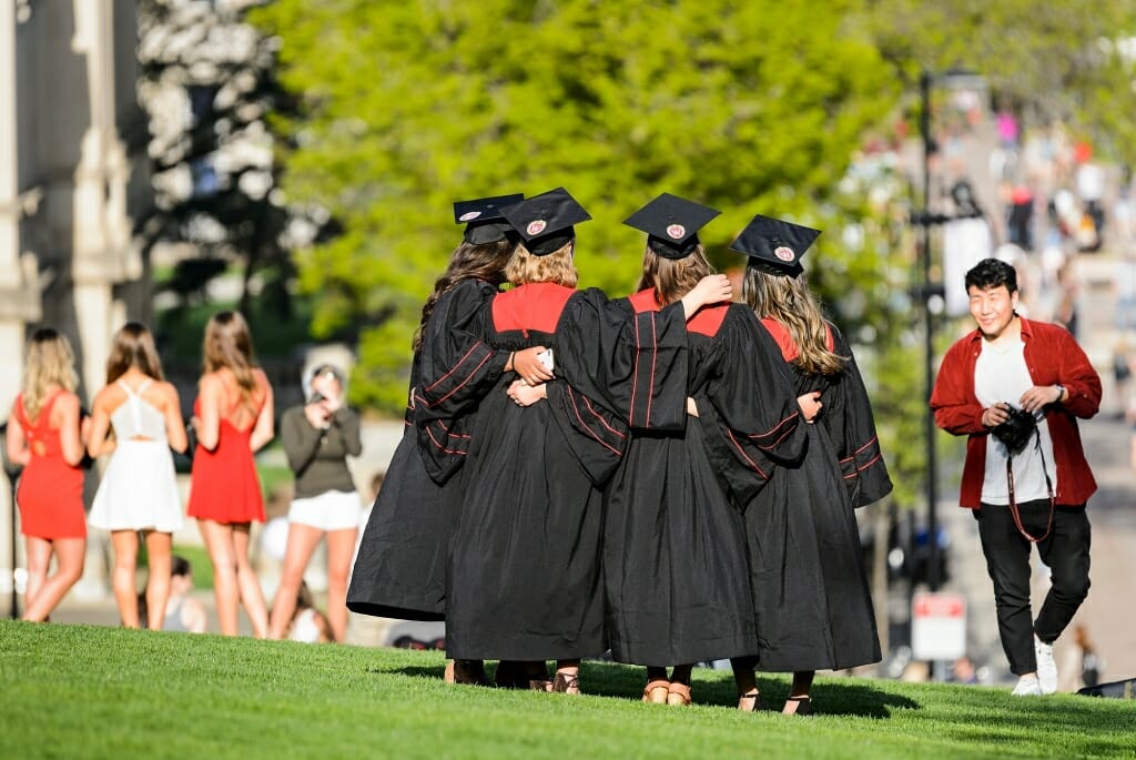 Soon-to-be graduates wear their graduation mortarboards and gowns and pose for pictures on Bascom Hill.