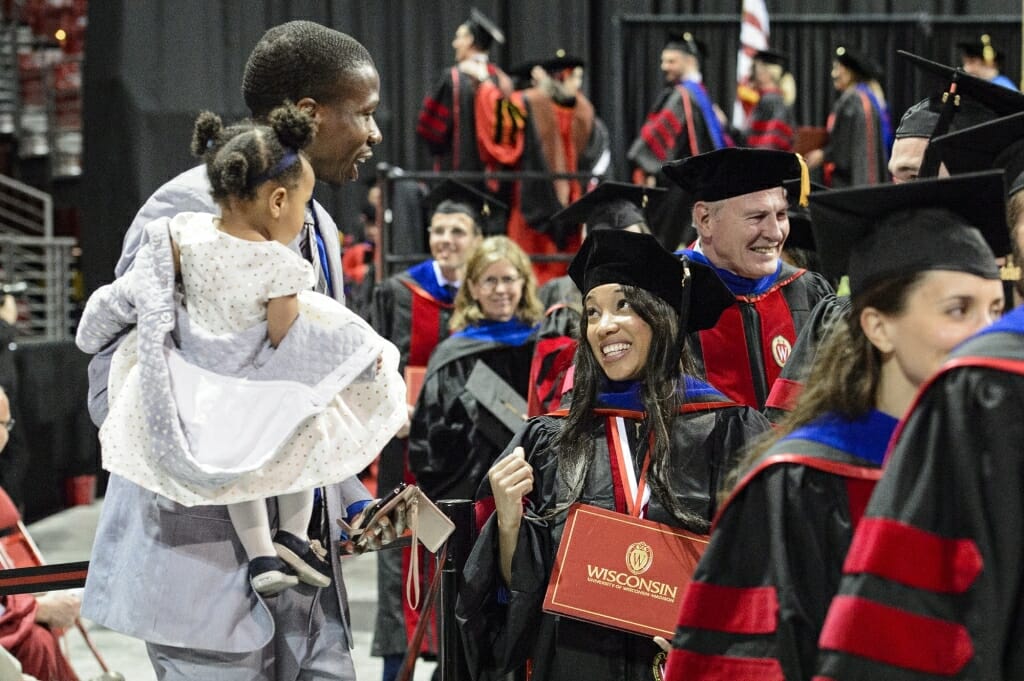 Photo of a graduate sharing a smile with her family after walking the stage.