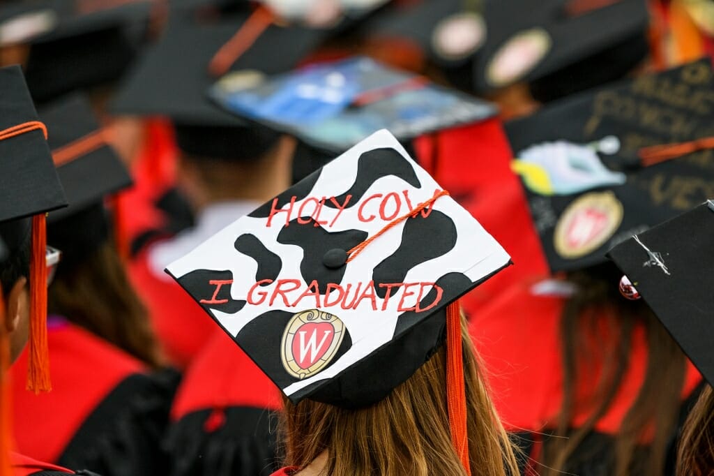 Photo of a Holstein-patterned mortarboard that reads, 