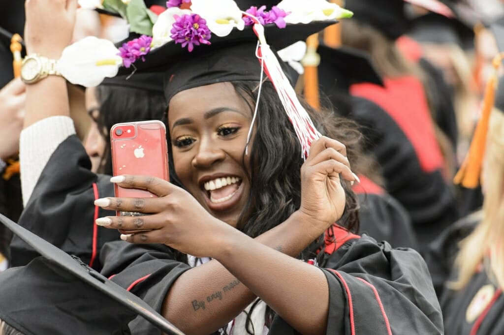 Photo of a student recording herself flipping her tassel to indicate she has graduated.
